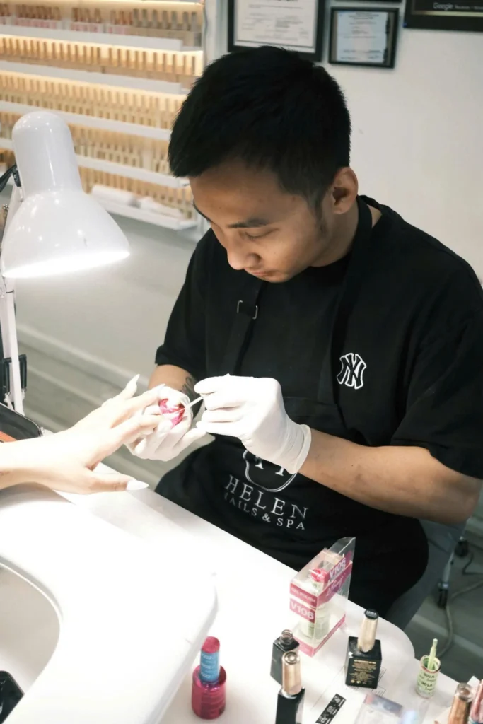 Nail technician performing manicure service at Helen Nails & Spa Jersey City